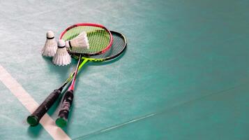 vit badminton badmintonbollar och badminton racketar på grön golv inomhus- badminton domstol mjuk och selektiv fokus på badmintonbollar och de racketar foto