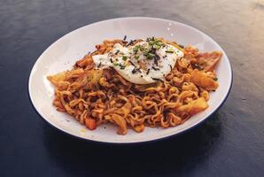 Vispa friterad spaghetti med friterad ägg toppade med vit sesam frön och tång foto