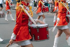 gata prestanda. närbild av kvinna trummisar händer i röd årgång enhetlig på de parad foto