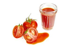 glas naturlig tomatjuice, färska röda tomater på vit bakgrund. foto