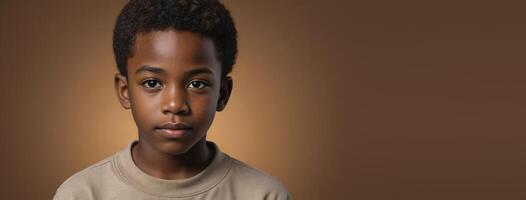 ett afrikansk amerikan juvenil pojke isolerat på en bärnsten bakgrund med kopia Plats. foto