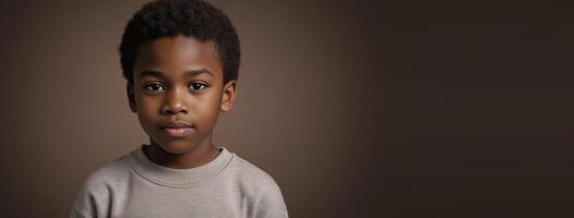 ett afrikansk amerikan juvenil pojke isolerat på en brun bakgrund med kopia Plats. foto