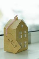 fastighetsförsäljningskoncept, pappersmodell av bostadshus. foto