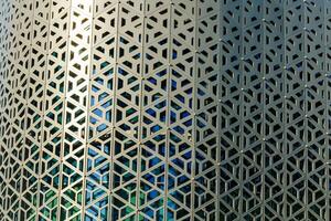 de textur av de beklädnad av en byggnad tillverkad av metall aluminium paneler med en ristade mönster. abstrakt bakgrund. foto