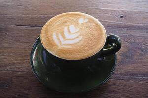 kopp av kaffe cappuccino på de trä- tabell foto