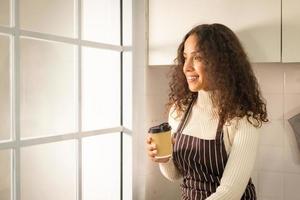 latinsk kvinna dricker kaffe i köket