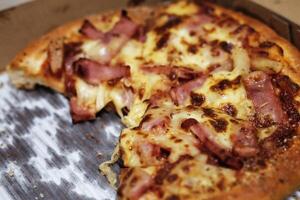skiva av pizza med skinka ost och tomat sås foto