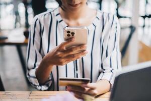 kvinna njut av med uppkopplad handla Ansökan på cell telefon och använda sig av kamera till skanna kreditera kort för fylla siffra till betalning foto