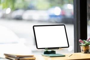 attrapp digital läsplatta på trä- skrivbord med tom skärm i kontor foto