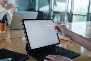 stänga upp hand av affärskvinna med digital läsplatta med tom skärm på trä- skrivbord. foto
