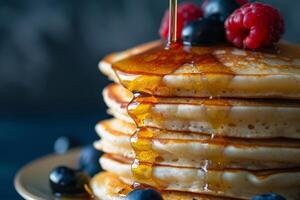 fluffig pannkakor duggregnat med lönn sirap och toppade med färsk bär. foto