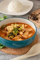 stängd upp traditionell thai kyckling grön curry med färsk vegetabiliska och ört i skål på tabell, thai mat begrepp foto