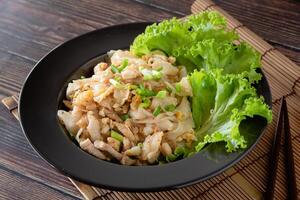 stängd upp Wokad ris nudel med kyckling, ägg och vegetabiliska på trä- tabell, kinesisk lätt matlagning foto