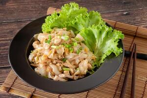 stängd upp Wokad ris nudel med kyckling, ägg och vegetabiliska på trä- tabell, kinesisk lätt matlagning foto
