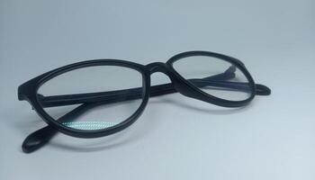 en par av glasögon med svart ramar på en vit yta foto