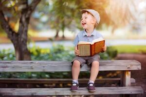 söt liten pojke läsning helig bibel bok på landsbygden foto
