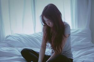 asiatisk flicka känsla ledsen och ensam i de sovrum under dämpa ljus foto