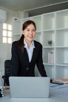 ung framgångsrik anställd eller företag kvinna på skrivbord på kontor. prestation karriär begrepp foto