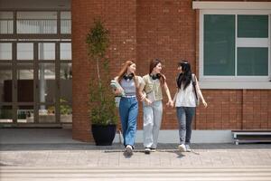 högskola vänner promenad till klass tillsammans. universitet studerande i campus prata och ha roligt utomhus foto