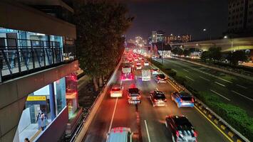 en upptagen gata på natt med bilar och bussar foto