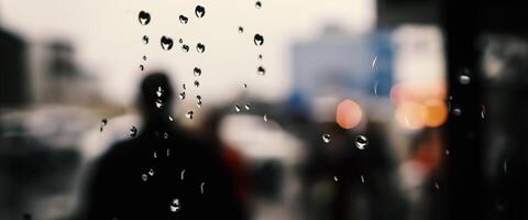 regn släppa på fönster glas av kaffe affär och suddigt stad liv bakgrund. regnig säsong och suddigt människor stad dag liv eller bokeh natt lampor utanför fönster. kaffe affär fönster täckt med regn vatten foto