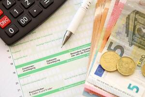fyllning tysk beskatta form bearbeta med penna och euro pengar räkningar stänga upp. beskatta betalande period foto