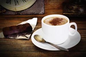 kopp kaffe med choklad på mörk bakgrund i retro vintage foto