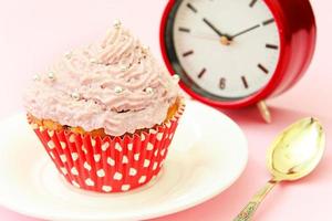 tårta med grädde, cupcake på rosa bakgrund. foto