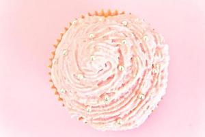 tårta med grädde, cupcake på rosa bakgrund. foto