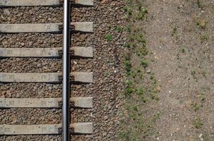 järnvägen ovanifrån, platt låg. del av spåret för tåg. Flygfoto över en järnväg från en drönare. bakgrund med plats för text. blanka järnskenor och betongslipers. foto