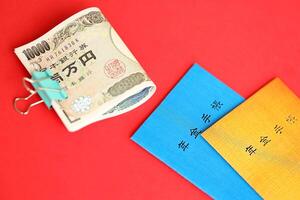 japansk pension försäkring broschyrer på tabell med yen pengar räkningar. blå och orange böcker foto