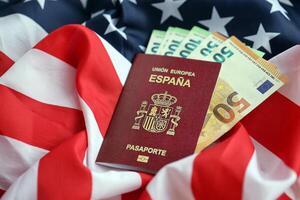 röd spanska pass av europeisk union och pengar på förenad stater nationell flagga bakgrund foto