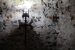 upplyst medeltida slott ficklampa hängande på en sten vägg, årgång objekt foto
