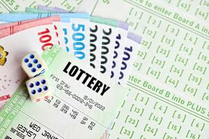 grön lotteri biljetter och indonesiska pengar räkningar på tom med tal för spelar lotteri foto