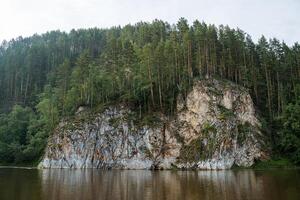en skön sten står på de Bank av de flod, en vit sten är översvämmad med vatten, en tyst berg flod, de vatten yta av de reservoar, de natur av ryssland bashkortostan. foto