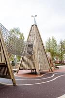 trä- pyramid, maska textavsnitt för barn, klättrande en glida, en rekreation parkera för barn, en sudd beläggning av asfalt. foto