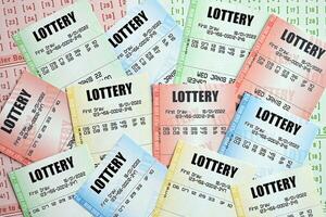 många lotteri biljetter på tom räkningar med tal för spelar lotteri foto