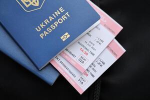 två ukrainska biometriska pass med luft flyg biljetter på svart turistiska ryggsäck foto