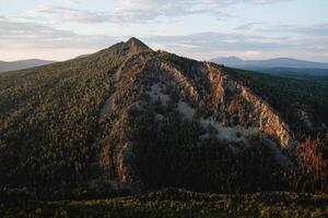 triangel- sten ljus falls på de stenar, kväll belysning av de fjäll, solnedgång Sol, berg i de sydlig uraler av ryssland bashkortostan. foto