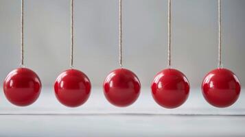 newtons vagga med röd bollar demonstrera fysik begrepp av Momentum, kinetisk energi, och bevarande foto