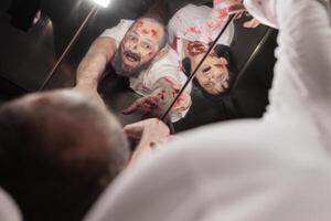 människor smittad förbi virus under utbrott vände sig in i zombies ser i hiss spegel. jäkel reanimerad lik fylld med blod och ärr fastnat i rulltrappa under apokalyps foto