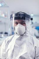 överarbetad forskare klädd i skyddande kostym mot invektion med coronavirus under global epidemi. foto