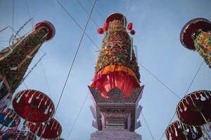 salak yom på wat phra den där hariphunchai i lamphun. de tradition av framställning merit, de lång färgade lott träd är dekorerad med annorlunda färgad papper och Kläder objekt till betala hyllning till de själar. foto