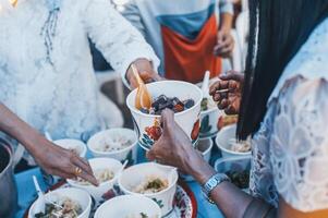 volontärer är ger fri mat till hjälp de hungrig fattig begrepp av mat delning foto