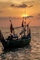 fiske båtar på de hav mot ett orange himmel på natt med tömma Plats för fotokopior. foto
