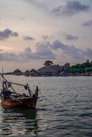 fiske båtar lutande på de havsstrand med de kartini strand turism i jepara, central java i de bakgrund. foto