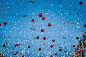 ny år eller jul festlig bollar och kransar hängande i rader mot de natt himmel. foto