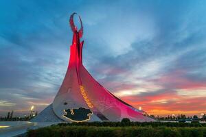 uzbekistan, Tasjkent - september 15, 2023 monument av oberoende i de form av en stele med en humo fågel på en skymning med dramatisk cliods i de ny uzbekistan parkera. foto