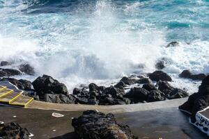 kraftfull vågor krascha längs de strandlinje av cinco ribeiras, en naturskön badning område på terceira ö, azorerna. foto