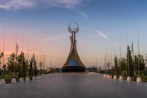 uzbekistan, Tasjkent - september 15, 2023 monument av oberoende i de form av en stele med en humo fågel på en skymning med dramatisk cliods i de ny uzbekistan parkera. foto